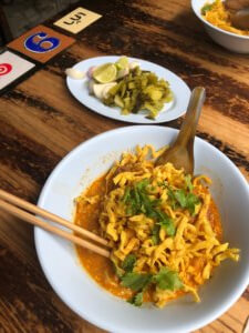 Bowl of Lanna food - Khao Soy with chopsticks, Chinese spoon and vegetables