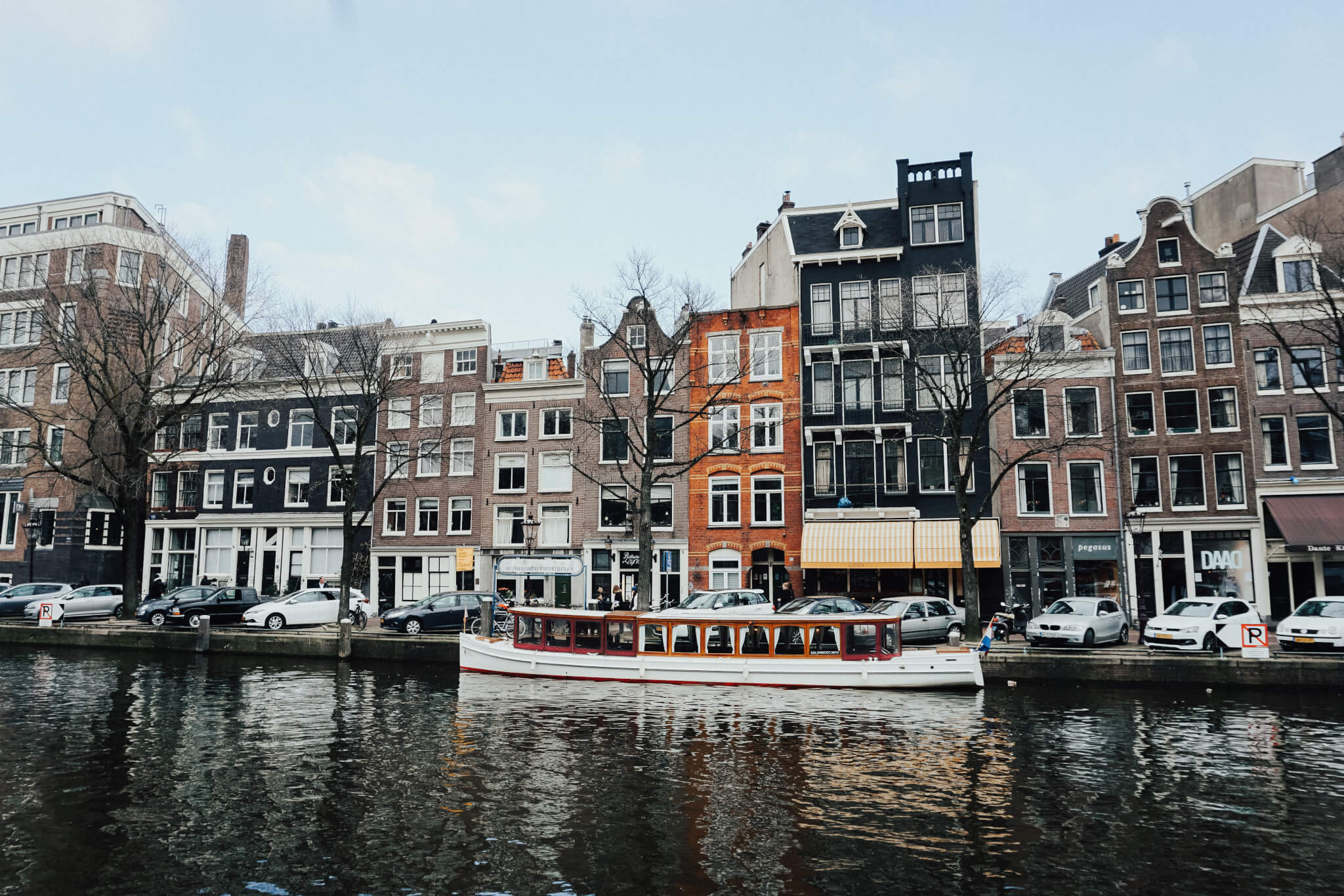 Pexels stock image of Amsterdam row of houses behind canal with boat