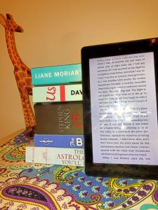 Kindle Fire 7 Against Real Books and Giraffe Ornament 