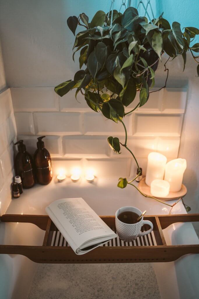 Pexels Image of bath candles book and cup of tea with plant in back