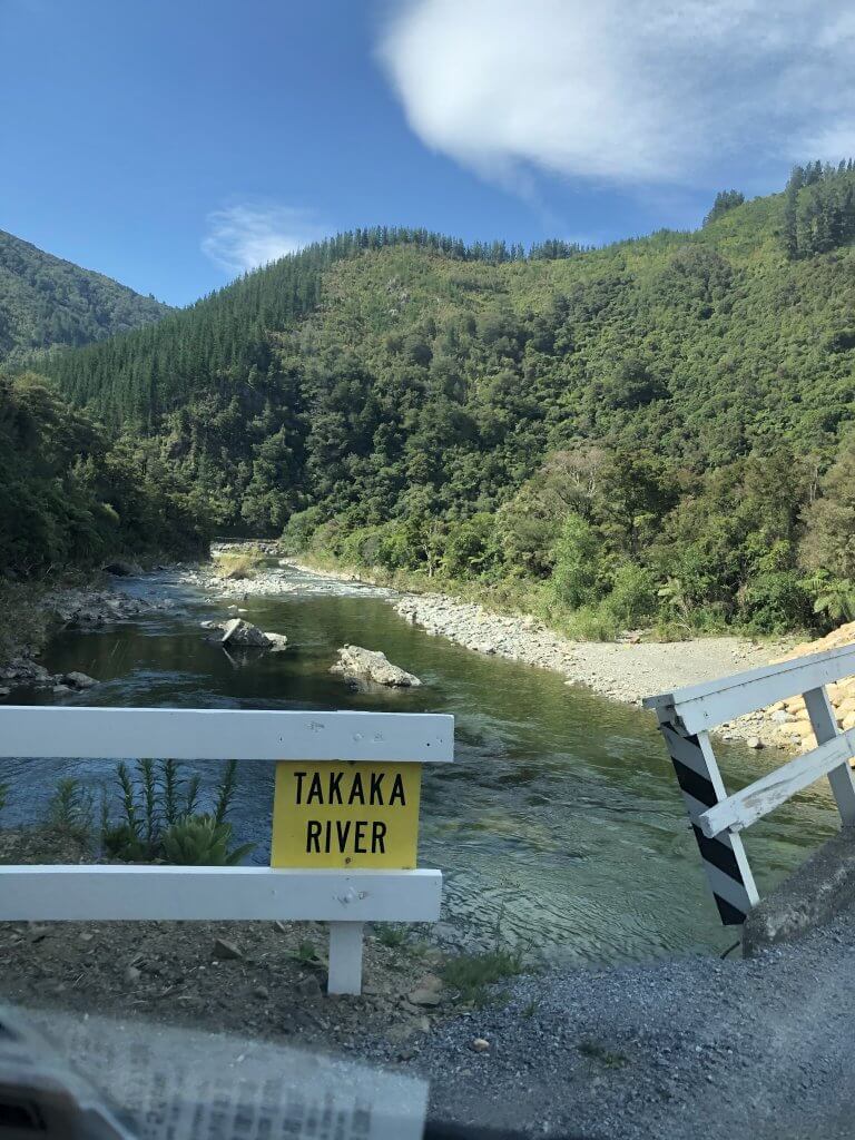 Takaka River sign with river in back New Zealand