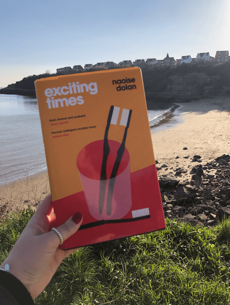 Exciting Times Book Review - My Book with beach in background