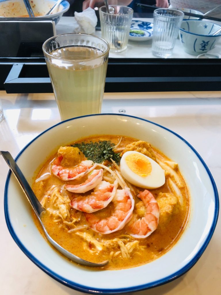 Laksa Soup in white bowl with drink. Picture credit yo Ingrid from Ingridzenmoments