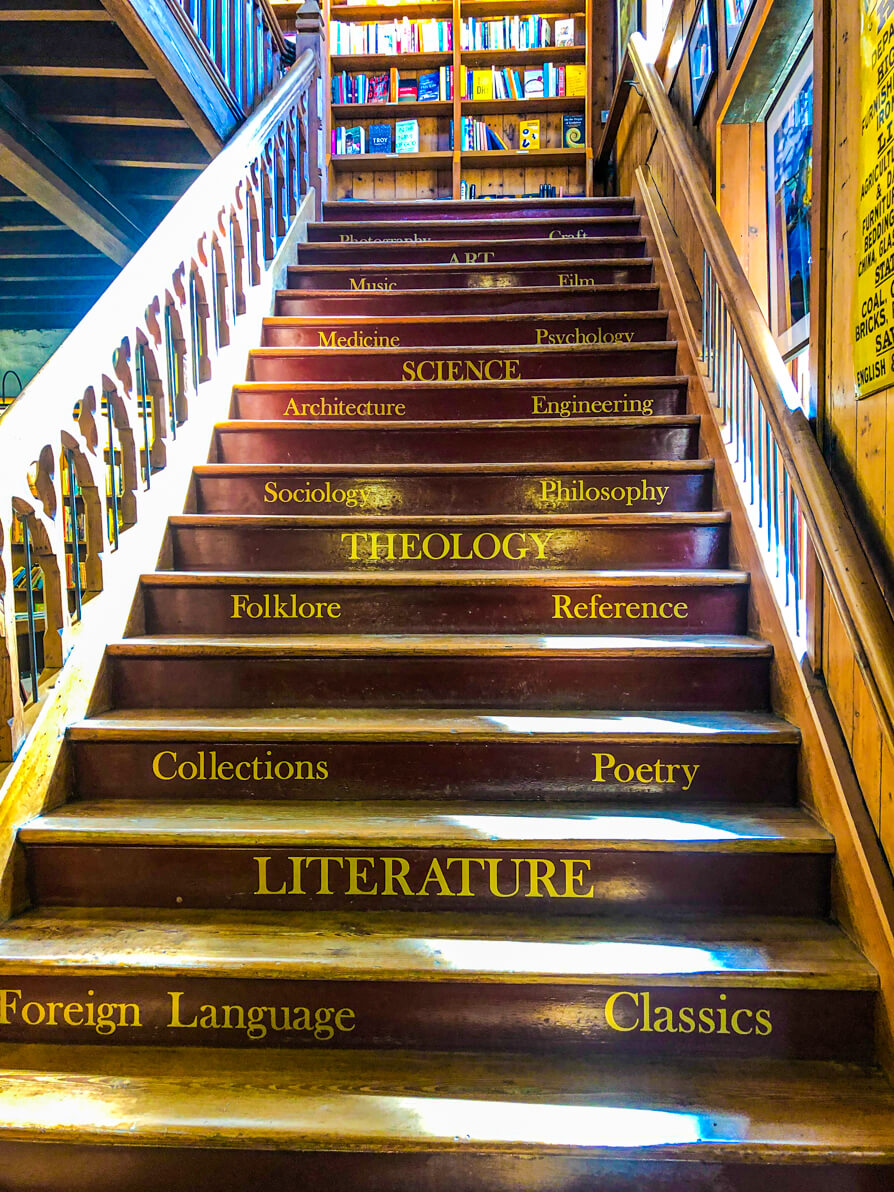 Staircase with genre names in Richard Booths Cinema Bookshop in Hay-on-Wye