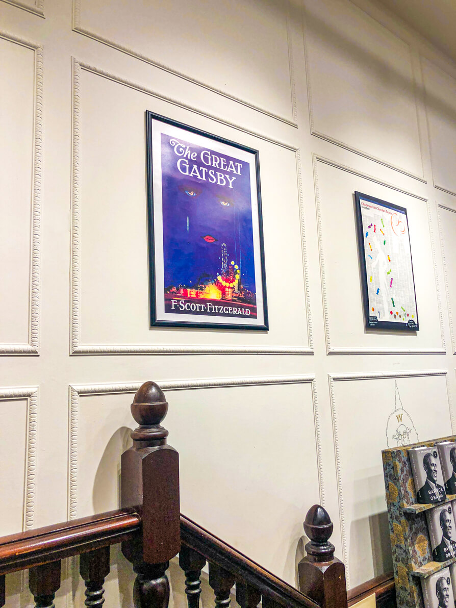 Image of The Great Gatsby original book poster on the wall above brown, wooden steps in Waterstones Cardiff