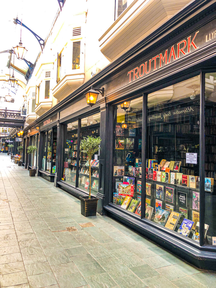 Image taken from outside of the store to the right showing Troutmark Books window and sign inside the Cardiff Castle Arcade.
