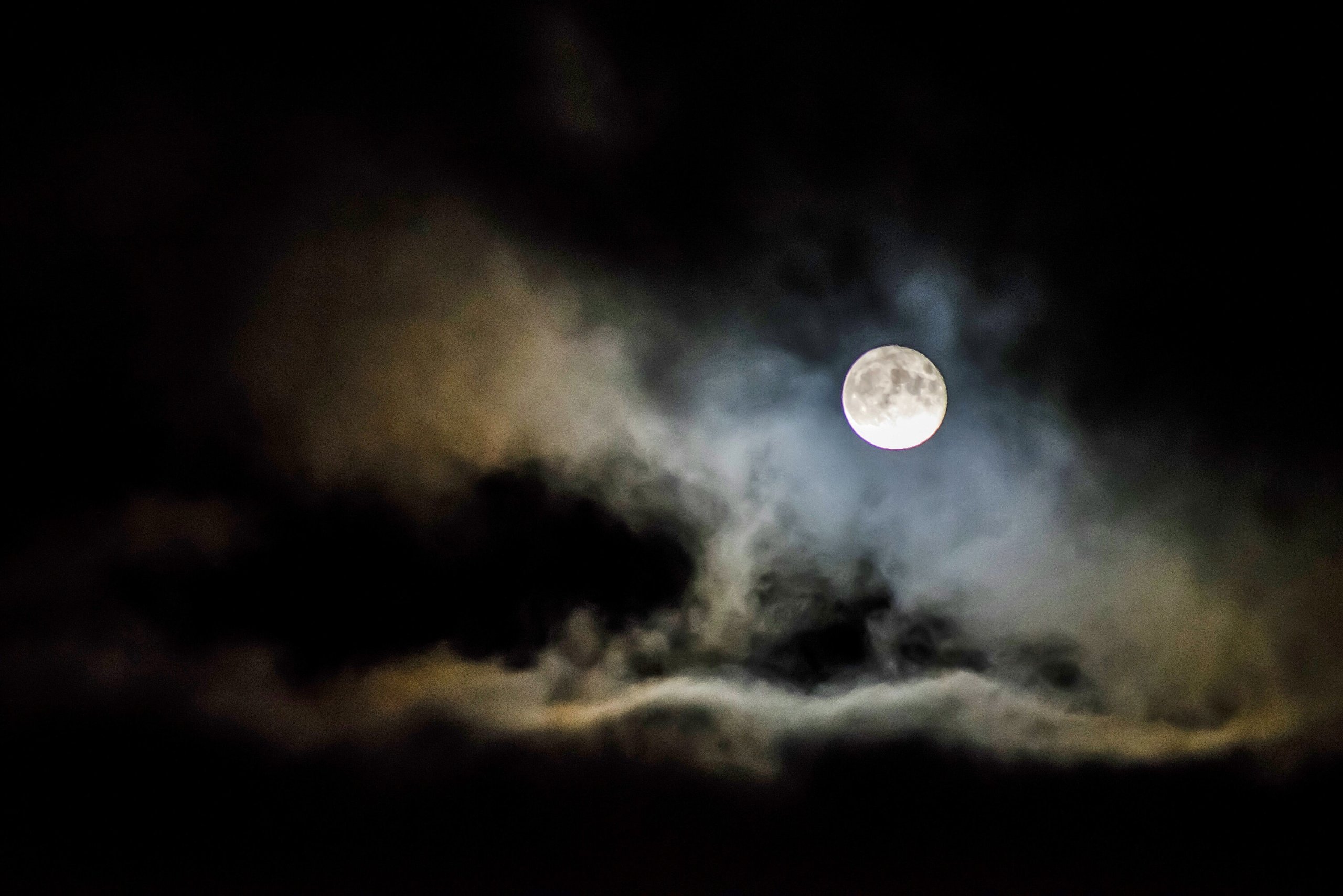 Pexels image of black sky lightened by a full white moon with faint clouds floating past