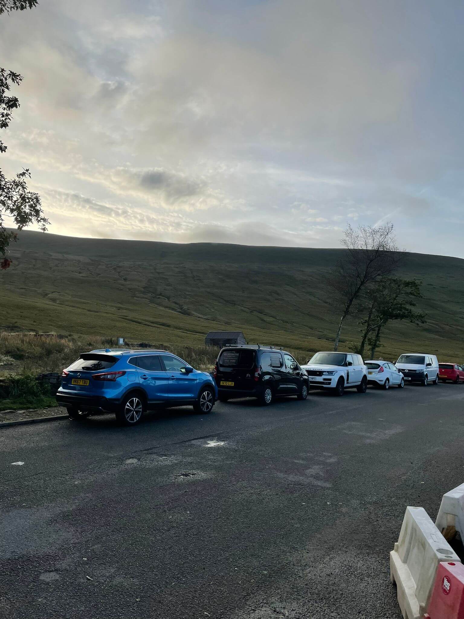Pen Y Fan Car Park with blue car and Pitstops sign in front and four other vehicles