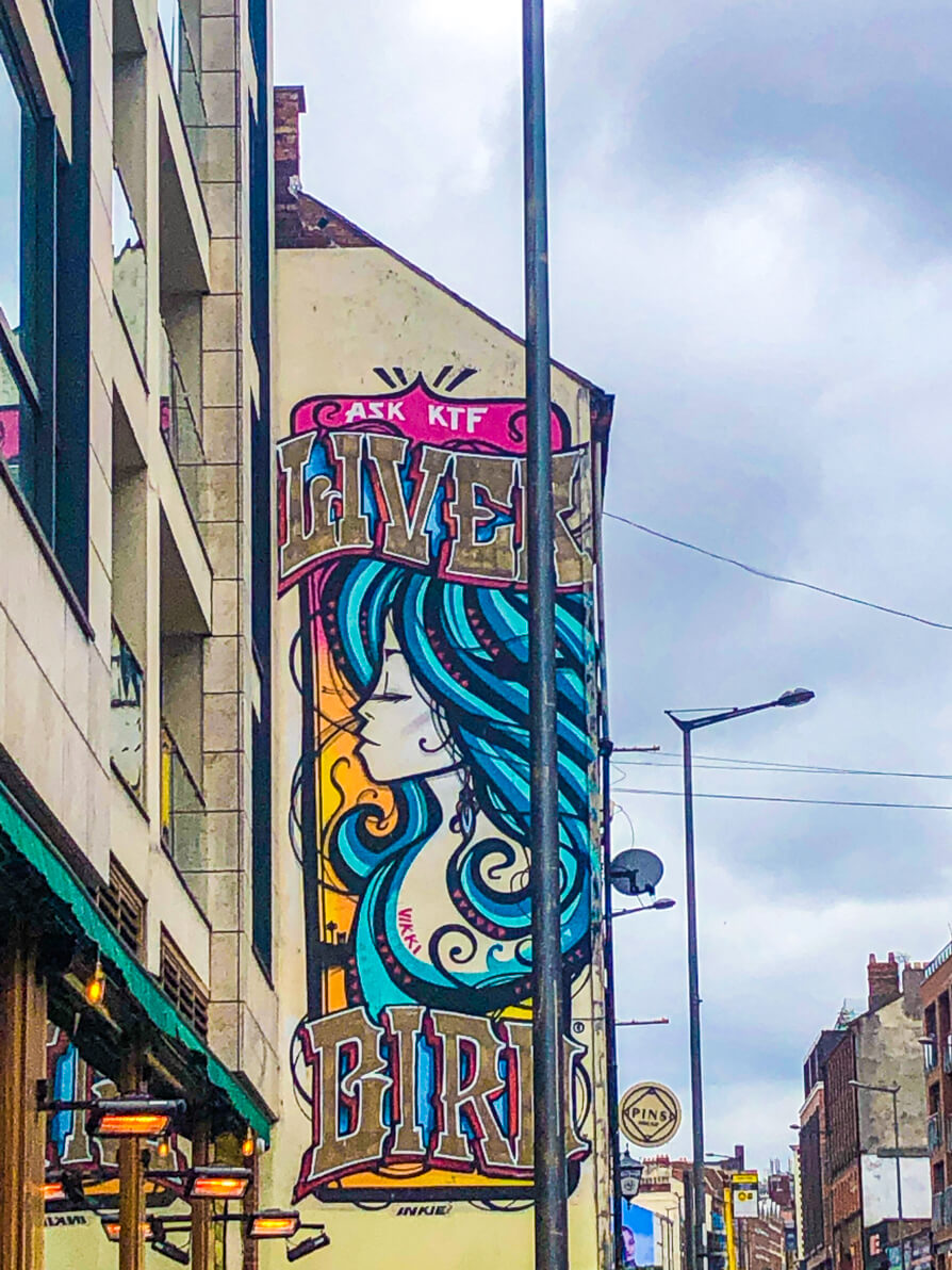 Street art in Liverpool of lady with blue hair and writing said 'Liverbird'