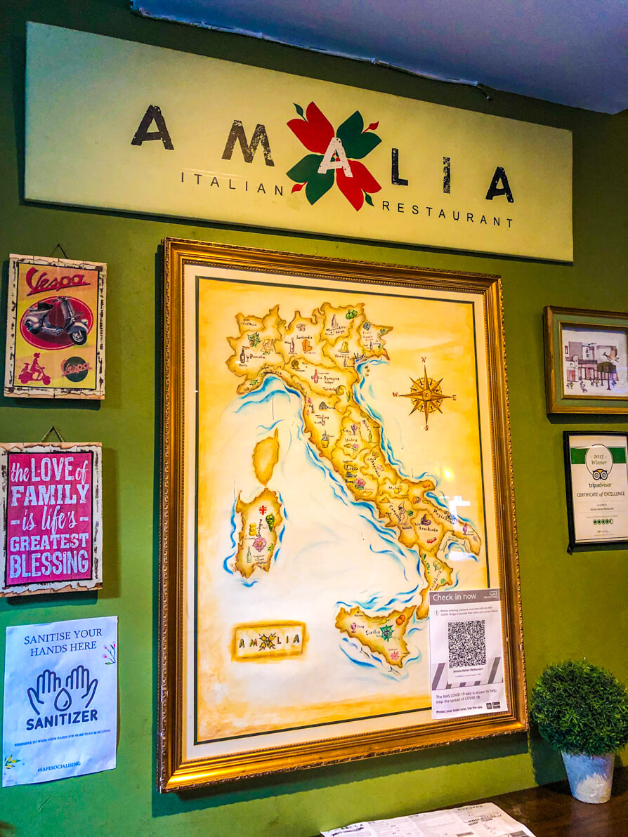 Image shows Amalia sign and map of Italy inside Amalia restaurant in Liverpool