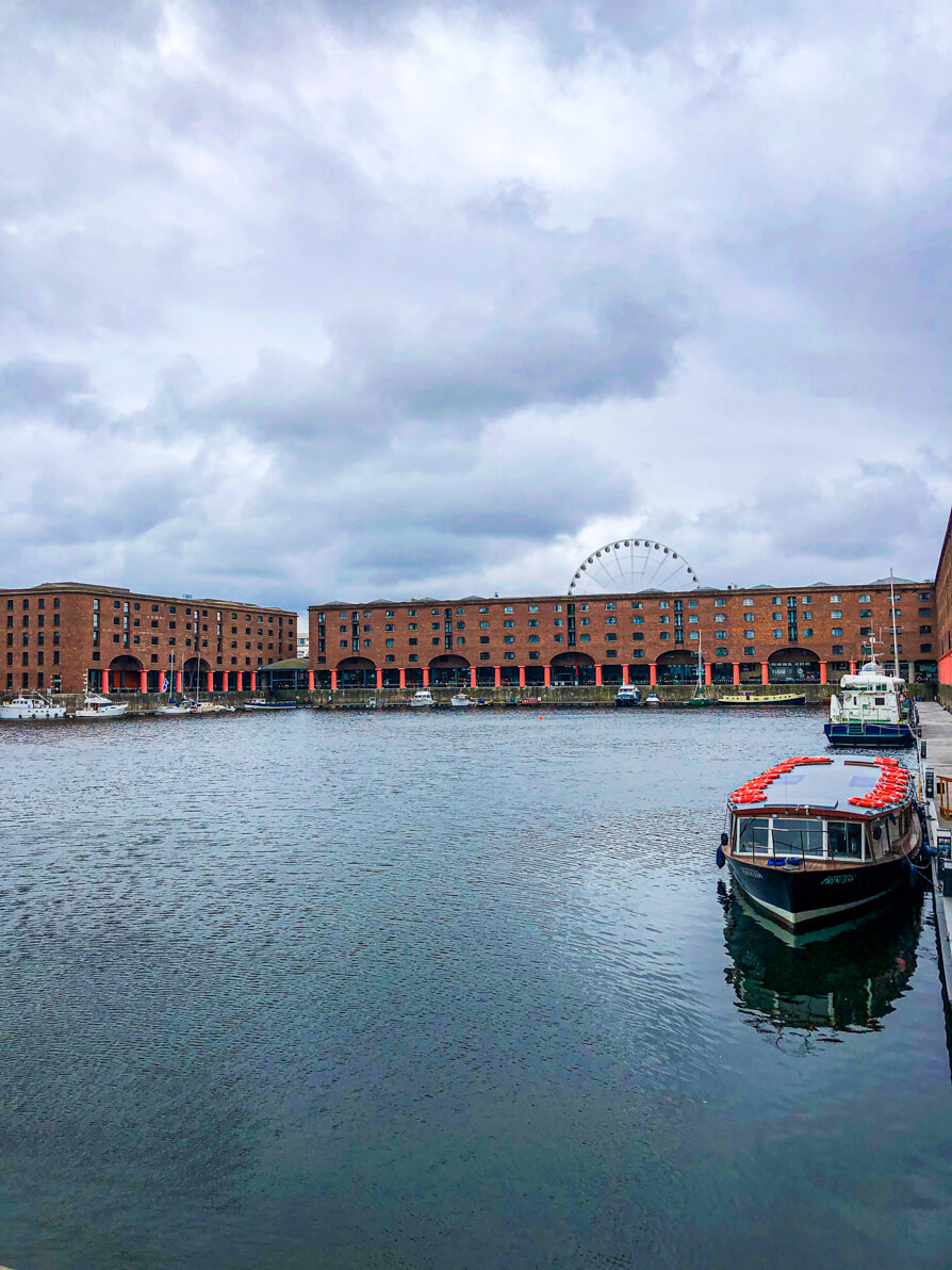 The Royal Albert Dock in Liverpool. Boat to the front right of picture and red buildings in background