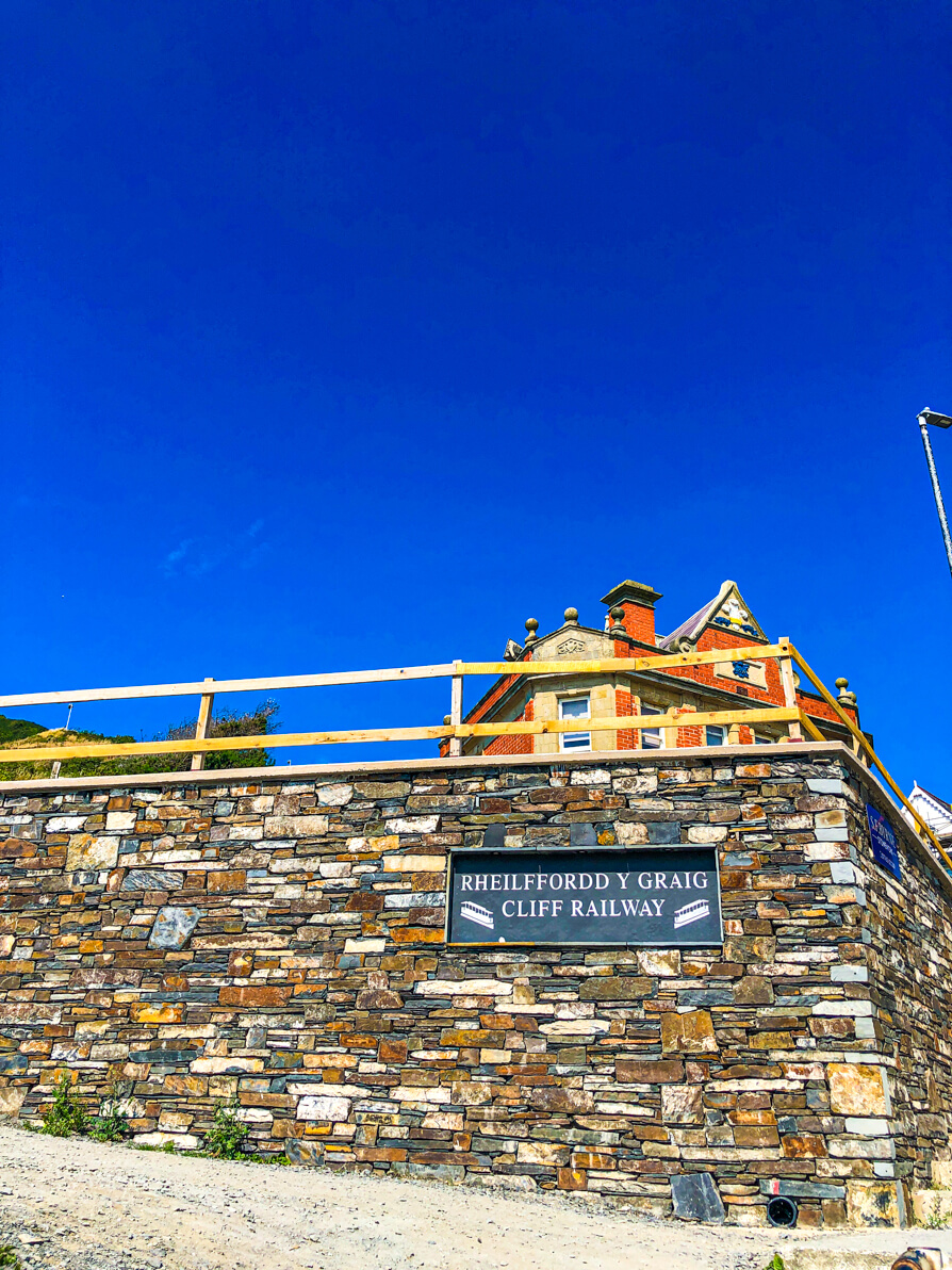 Entrance to the Cliff Railway in Aberystwyth. Image shows brick wall with Cliff Railway sign and red building in background