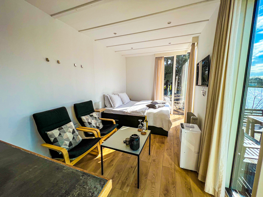 Interior of Airbnb Delft shows two chairs, table, bed and tv