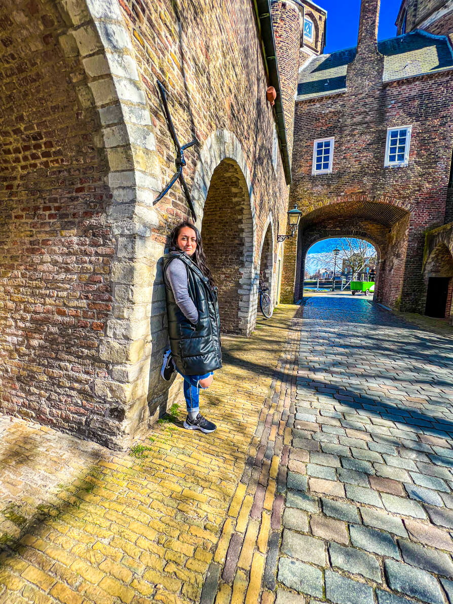 Shireen leaning on the wall of Oospoort Delft Holland