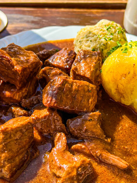 Goulash, knoedel and gravy on a white plate in Erfurt Germany Munich restaurant 