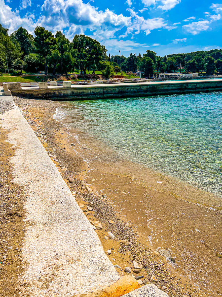 Valkane Beach in Stoja Pula Croatia from the right hand side looking over the wall, sand and water