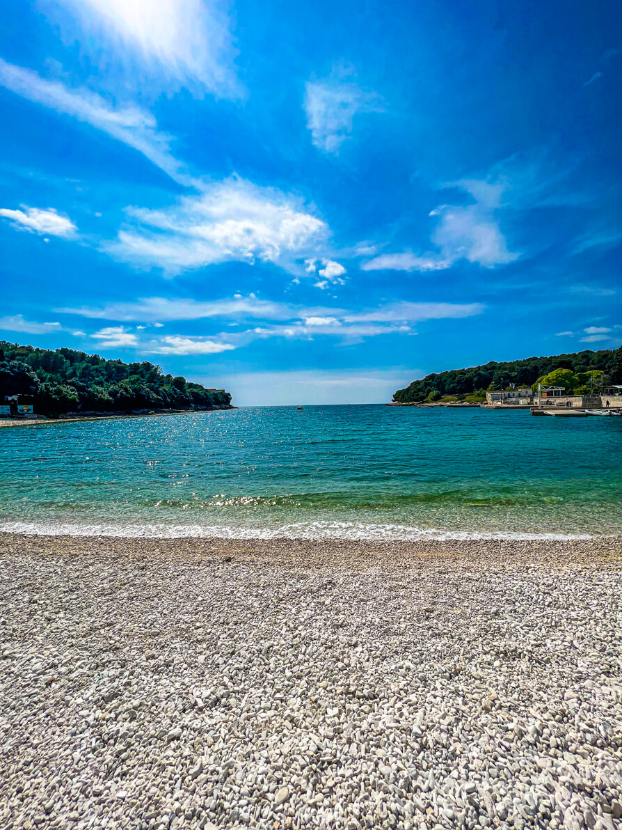 Valsaline Beach in Pula Croatia from the middle of beach with woodlands either side