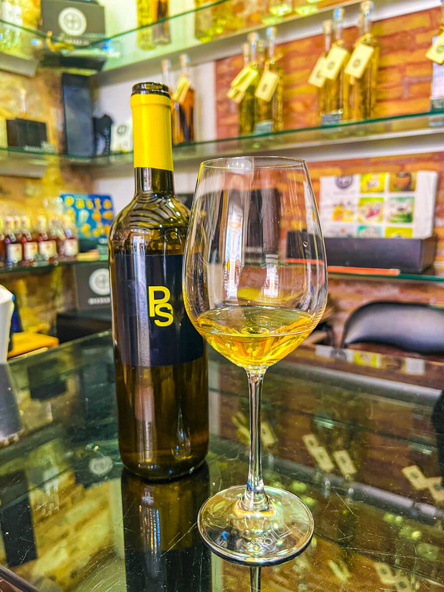 Close up image of a white wine bottle and glass of white wine in a wine shop in Zadar Croatia