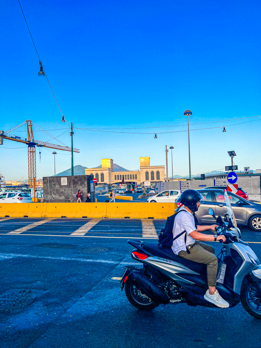 Image of Naples ferry port from the road with vespa in forefront and cranes in background