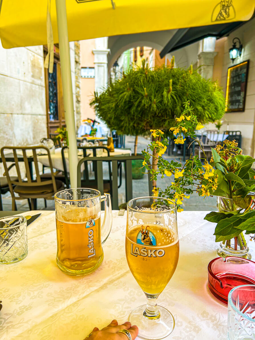 Image of two Lasko beers in glasses on a a beige table in Slovenia