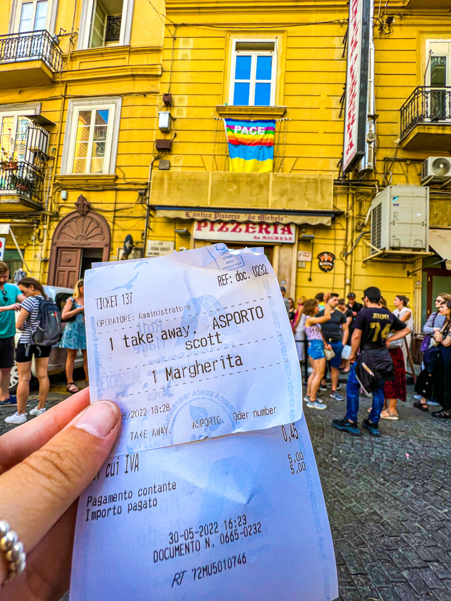 Image of our receipt for pizza held up outside pizza at Pizzeria Michele in Naples Italy
