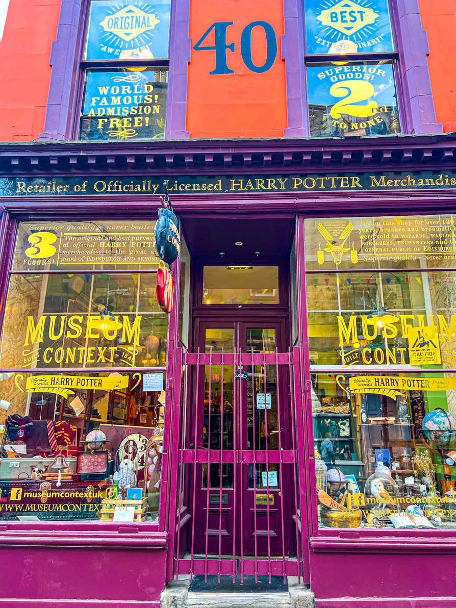 Exterior shot of Museum Context on Victoria Street in Edinburgh. The shop is purple with Harry Potter memorabillia in every window.