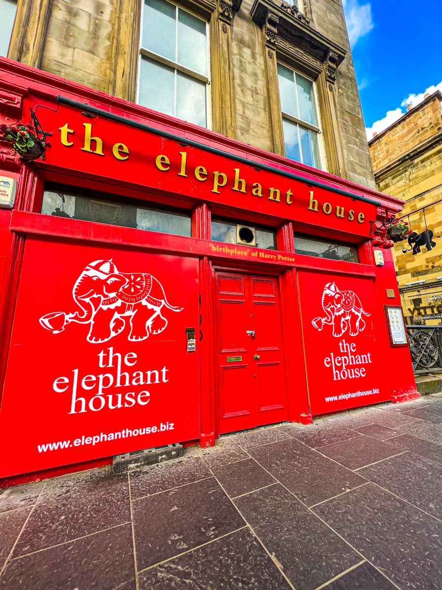 Exterior of Elephant House in Edinburgh. Building is ref with gold writing saying 'the elephant house' and 'birthplace of Harry Potter'