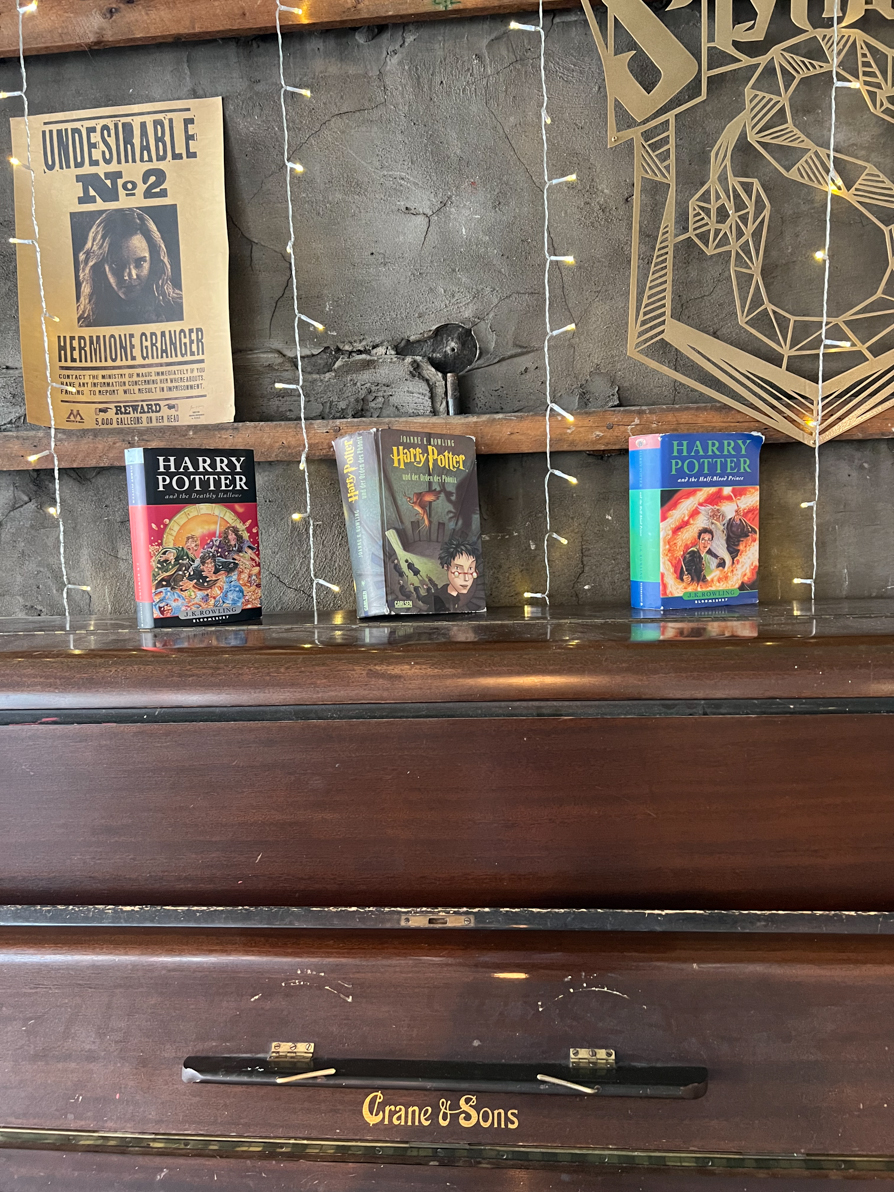 Three Harry Potter books stood upright on a piano in Nicolsons Cafe in Edinburgh