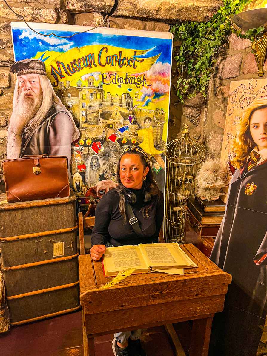Shireen on the second floor of Museum Context at the desk with Dumbledore and Hermione behind