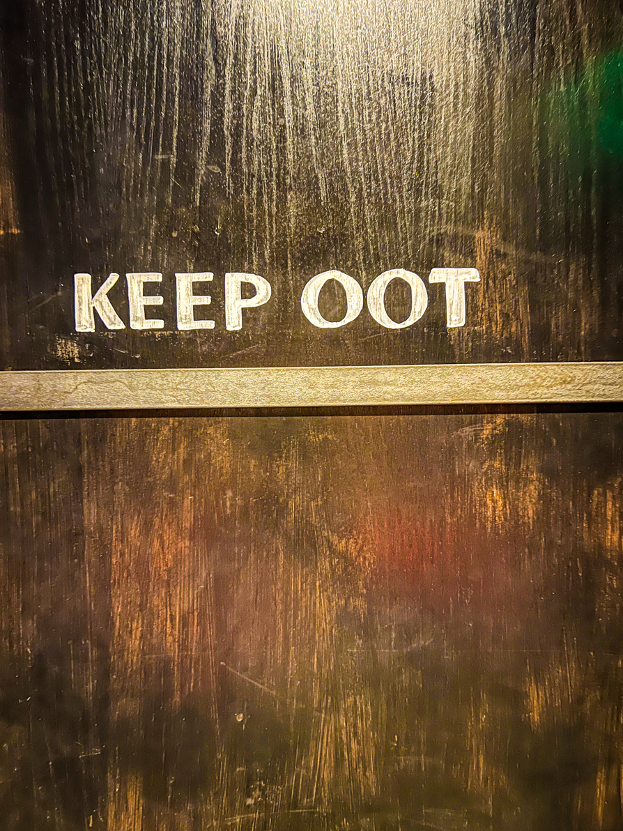 Sign saying ;Keep oot' on a door in a pub in Edinburgh Scotland