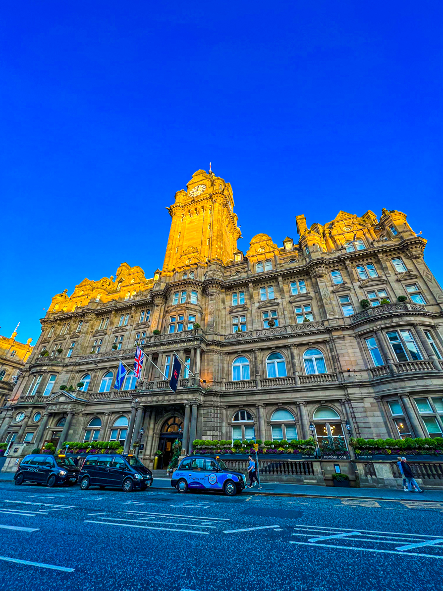 Exterior of Balmoral Hotel in Edinburgh from across the street showing the full wide shot of the grand hotel at sun down