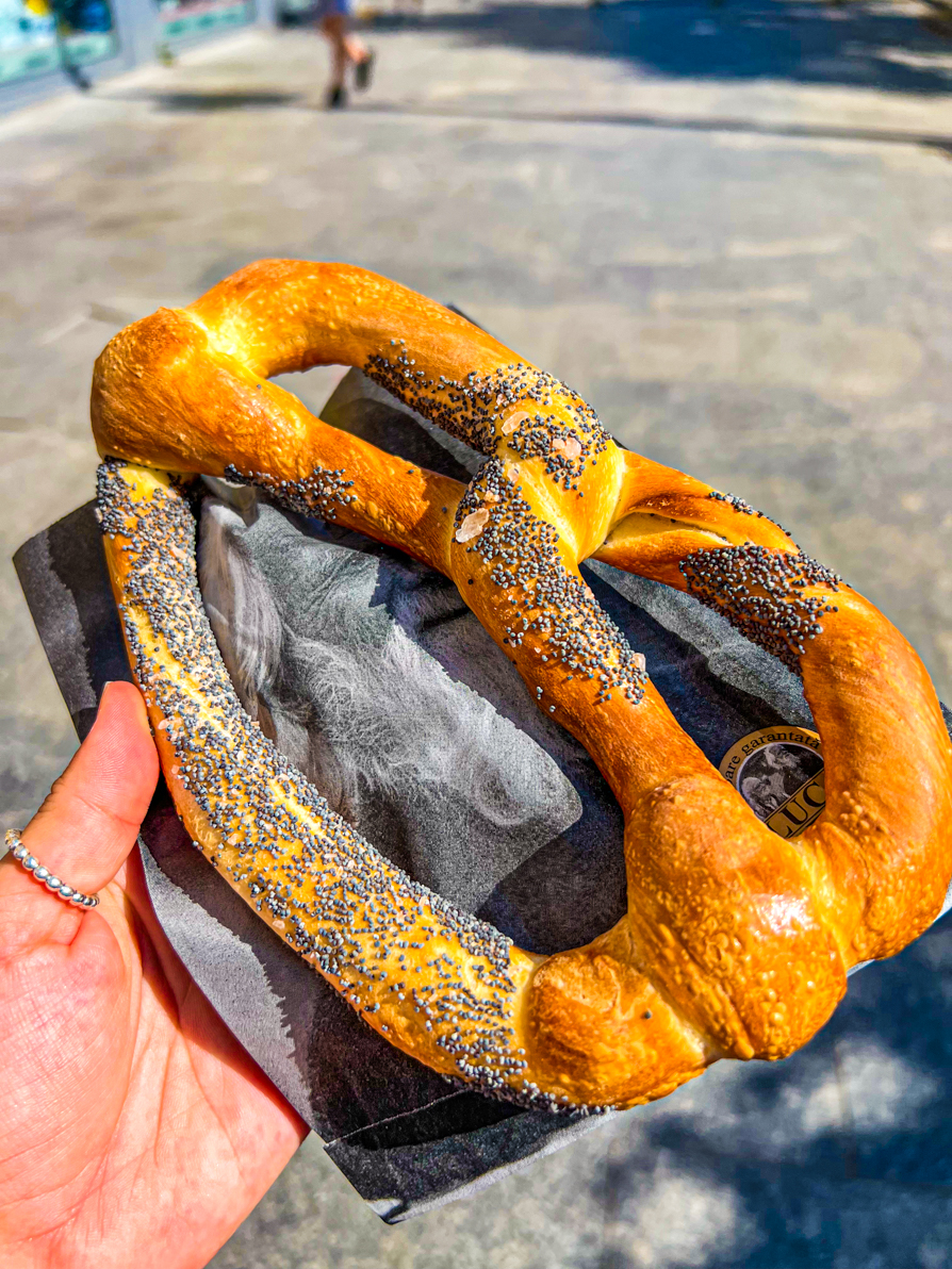 Image of Shireen's left hand holding up pretzel in street of Bucharest