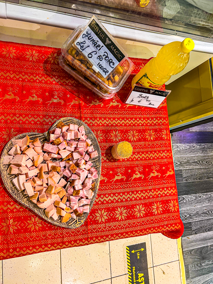 Image of free tastings of pork in a heart-shaped bowl on a red table in Bucharest Romania