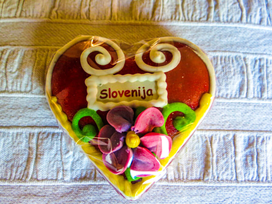 Image of a Slovenian gingerbread in heart shape with Slovenija written on it. Image credit to Heather Cole from Conversant Traveller