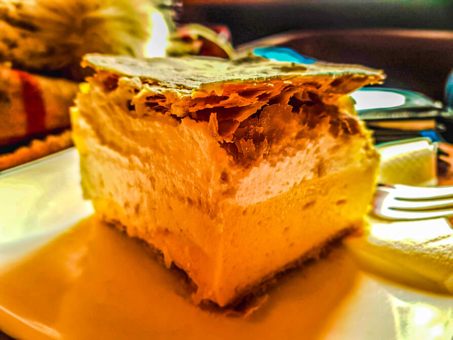 Image of Lake Bled cream cake on a white plate. Image credit to Joanna from The World in my Pocket