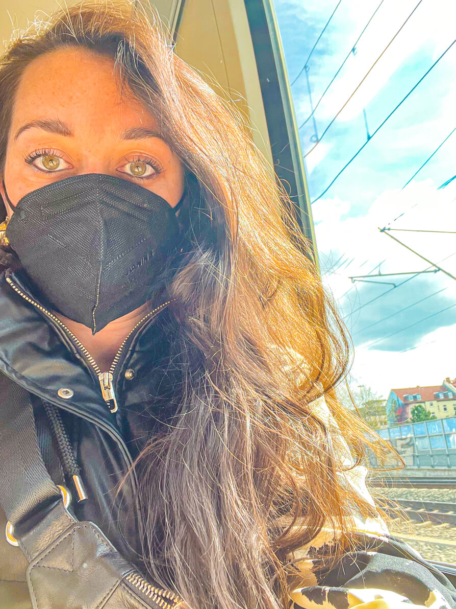 Image of Shireen wearing a black mask on a train in Germany