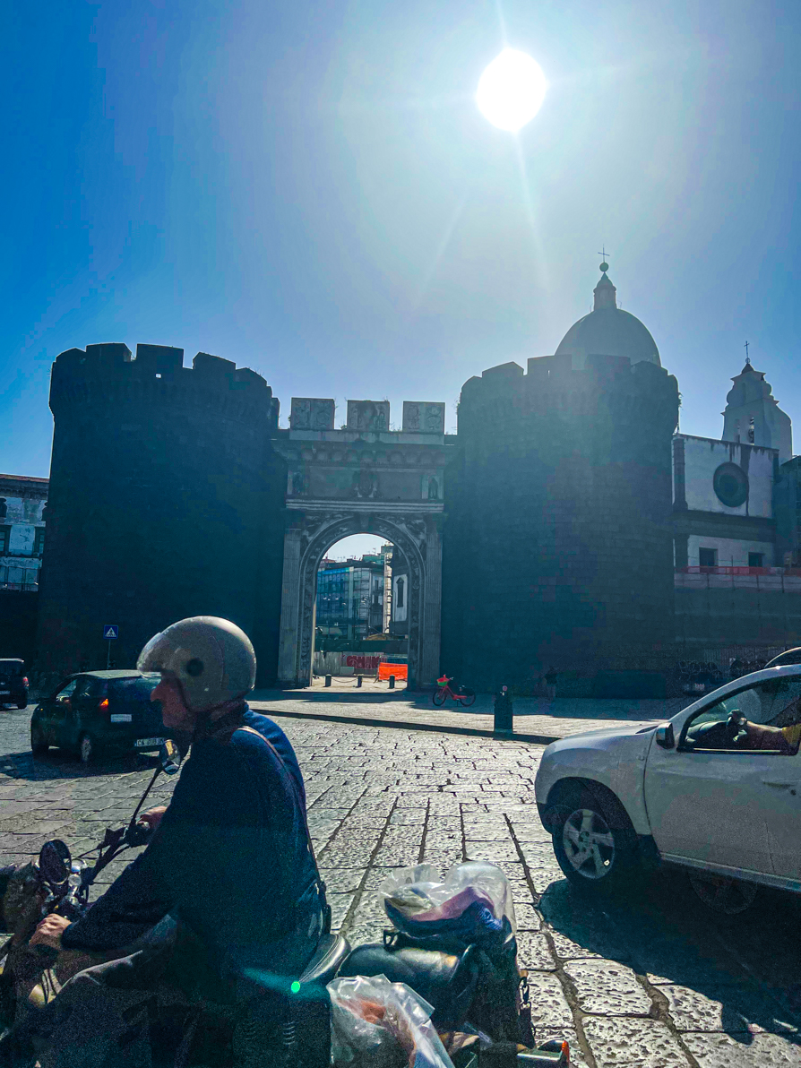 Image of Castle walls in Naples Italy with motorbike rider in front