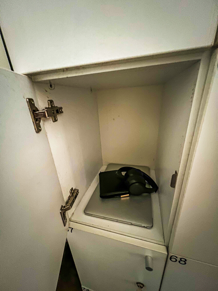 Image of 1 white locker with passport headphones and laptop inside in bedroom of First Hostel Bucharest Romania