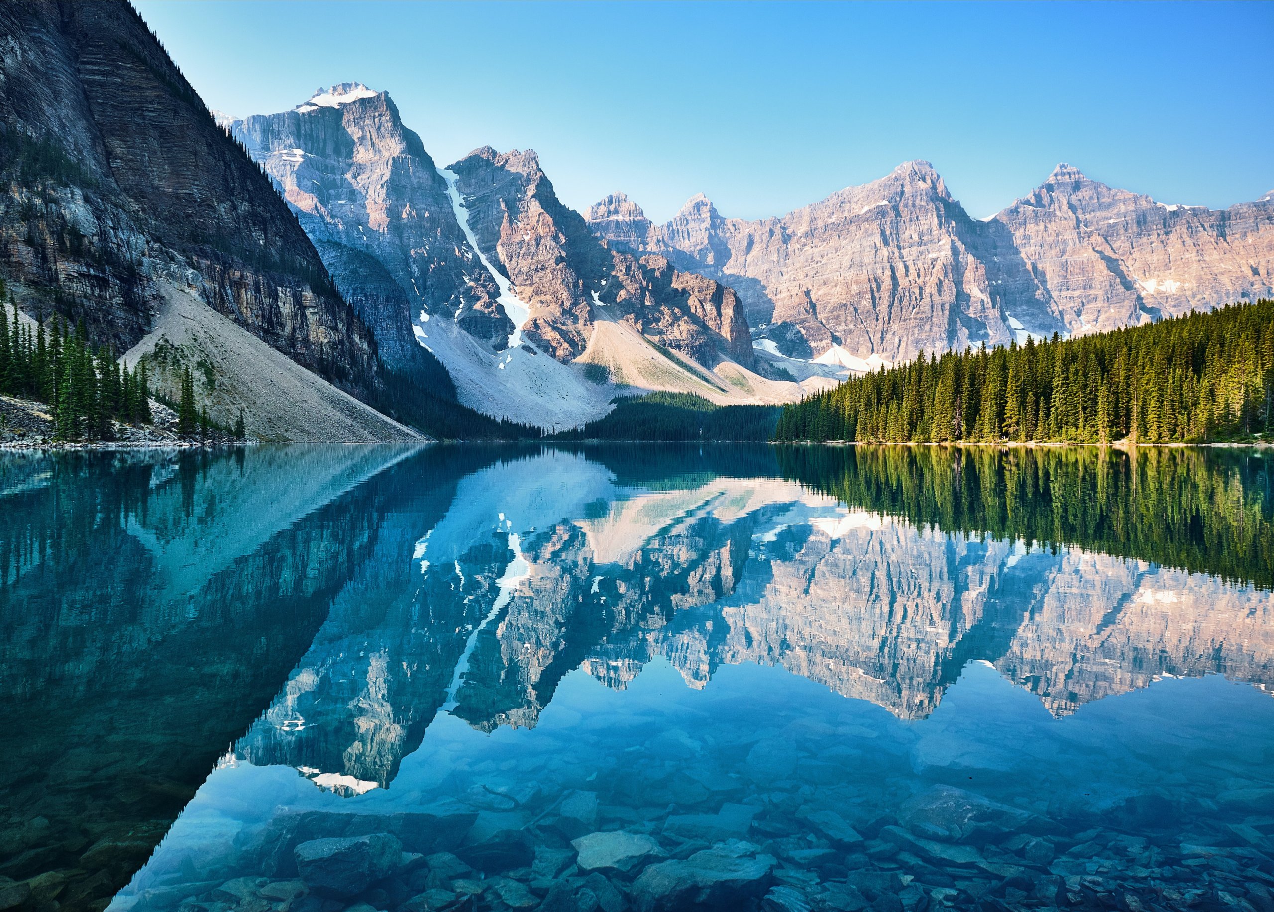 Unsplash credit. Image of Canadian Lake with mountains in background and reflected on water surface