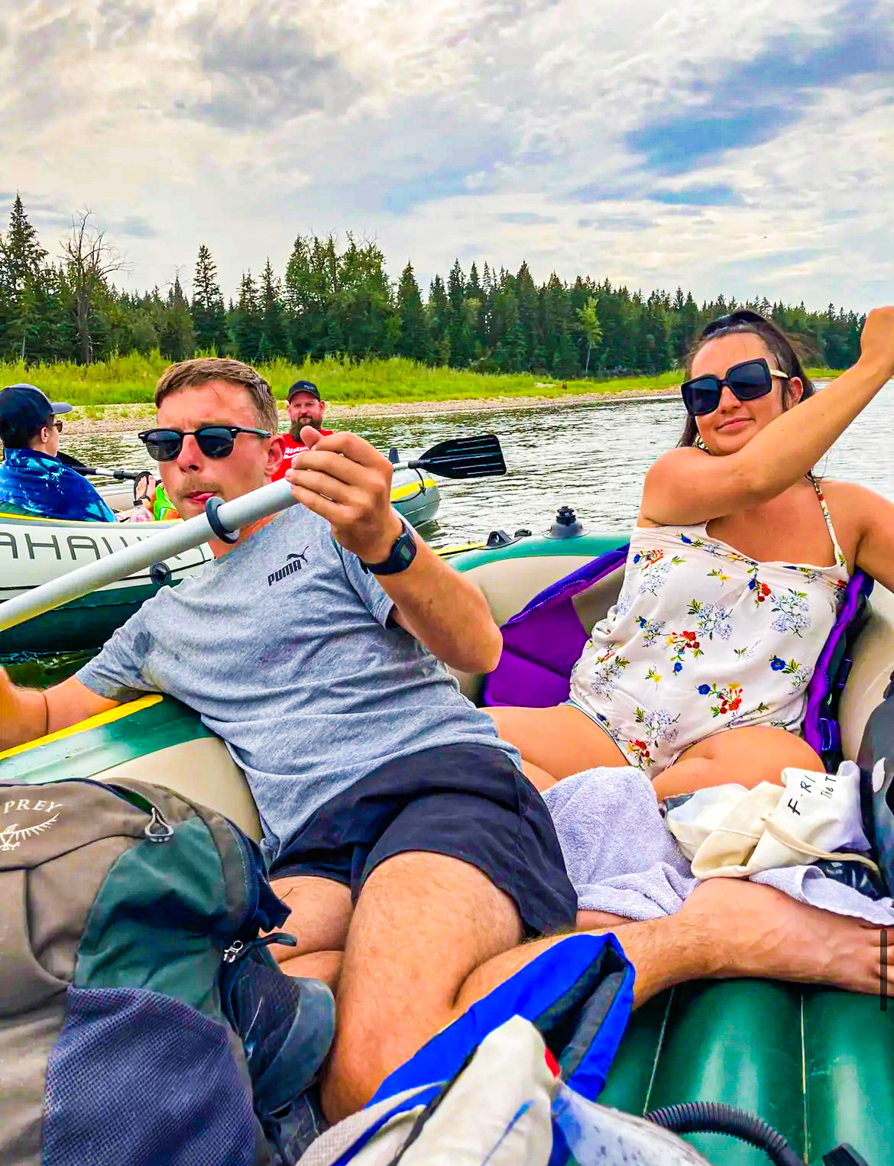 Image of Shireen and Scott paddling either side of the inflatable boat on Red Deer river floating in AB Canada