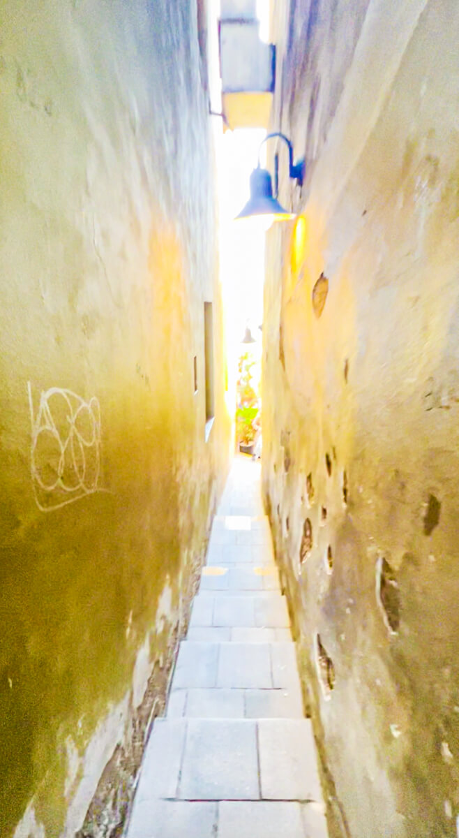 Image of the  most narrow street in Prague between yellow walls