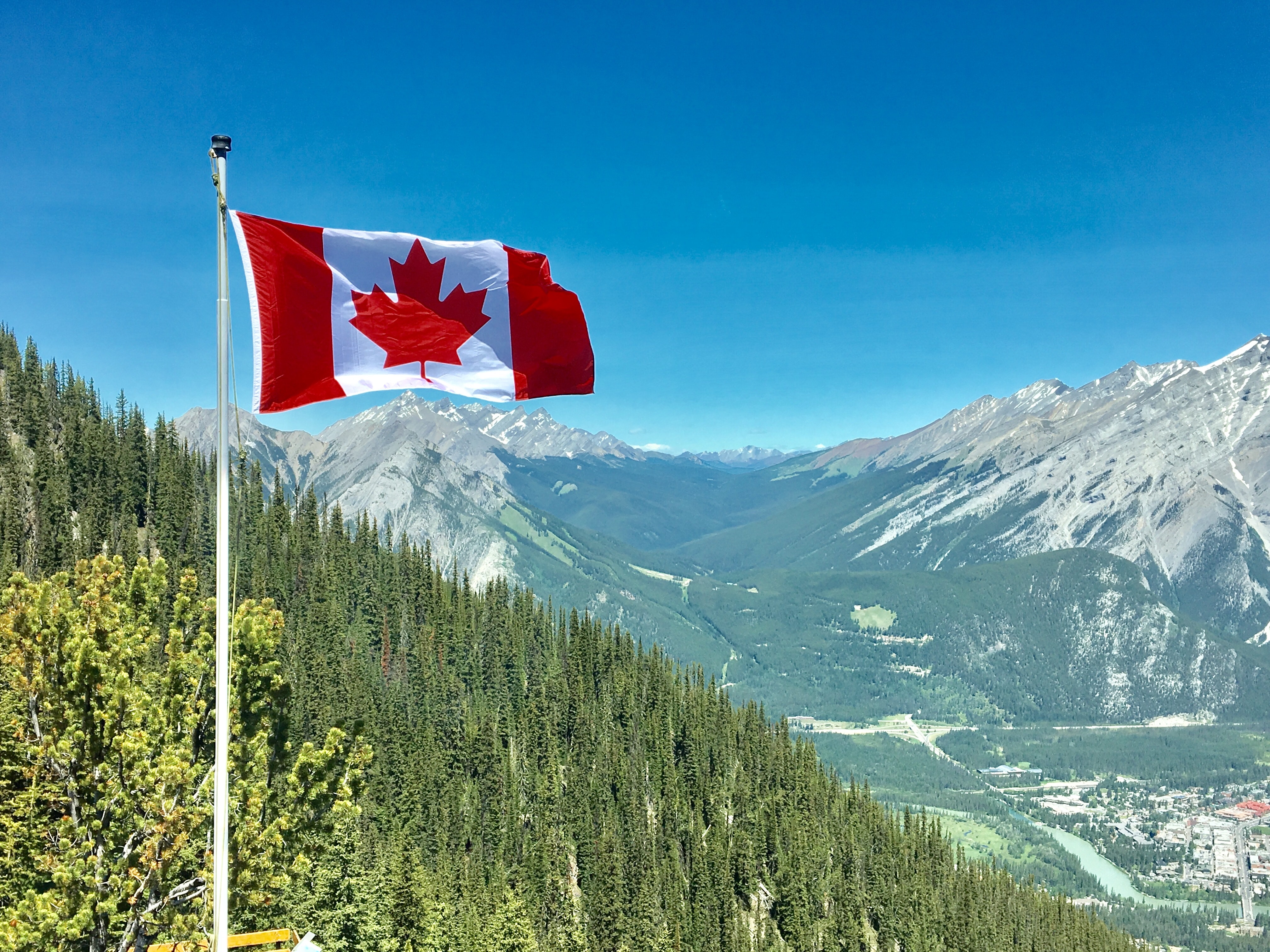Image of Canadian flag flying with mountains in background