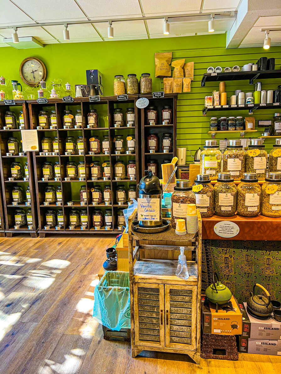 Inside of Banff Tea Co. with selection of tea leaves on the wall in pots in Banff