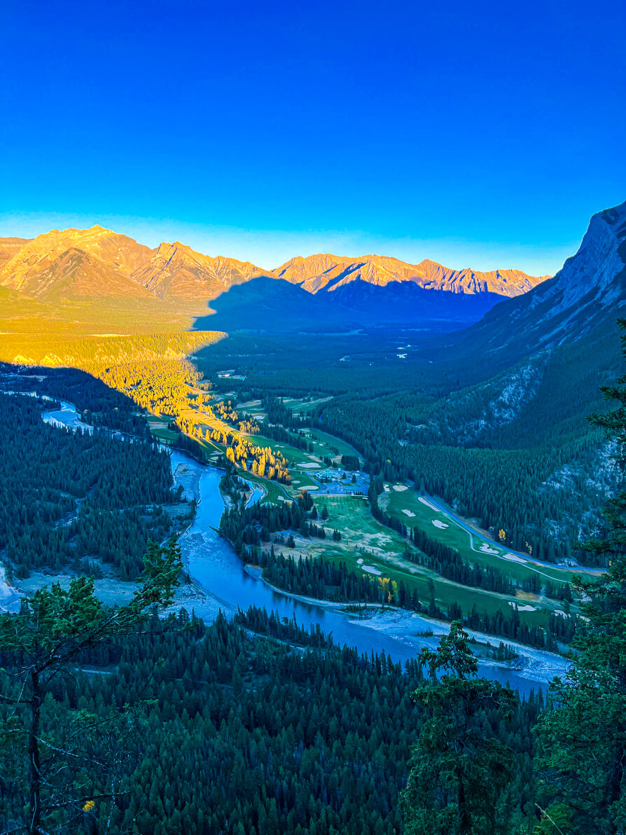 Image of Hoodoos, Golf Course and river in front of Rocky Mountains and blue sky in Banff as seen from Tunnel Mountain