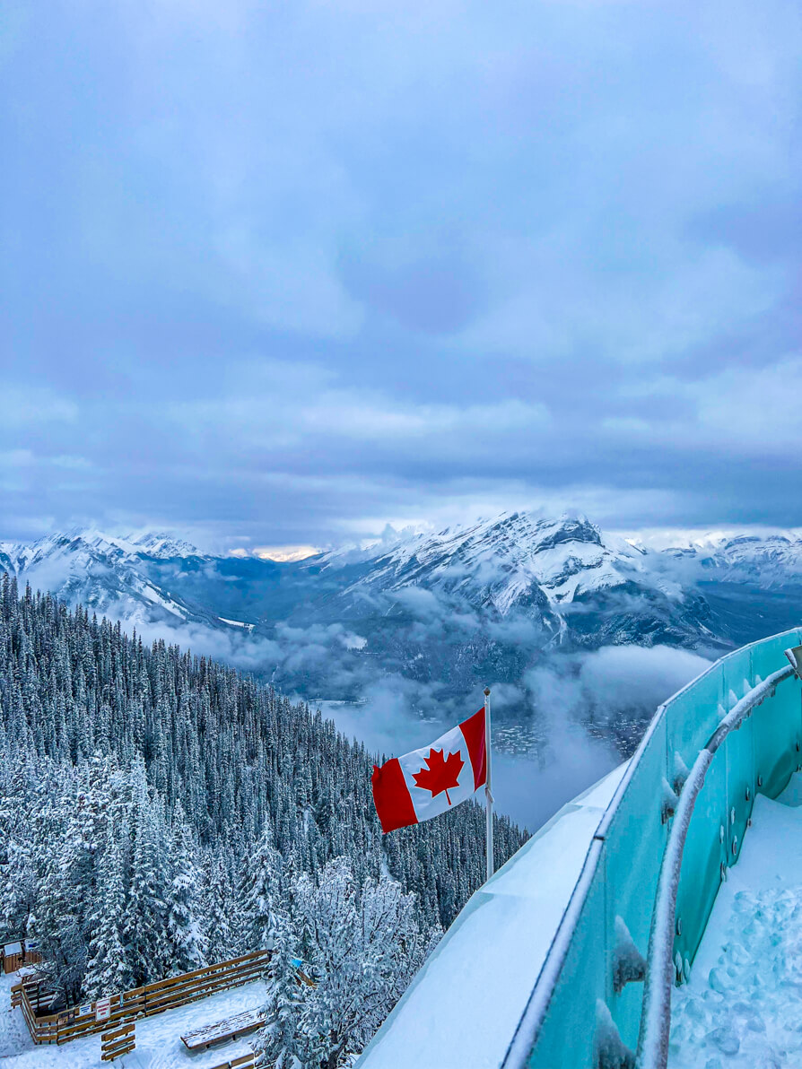 image of Banff National Park from top of Sulphur Mountain with Canada flag in centre