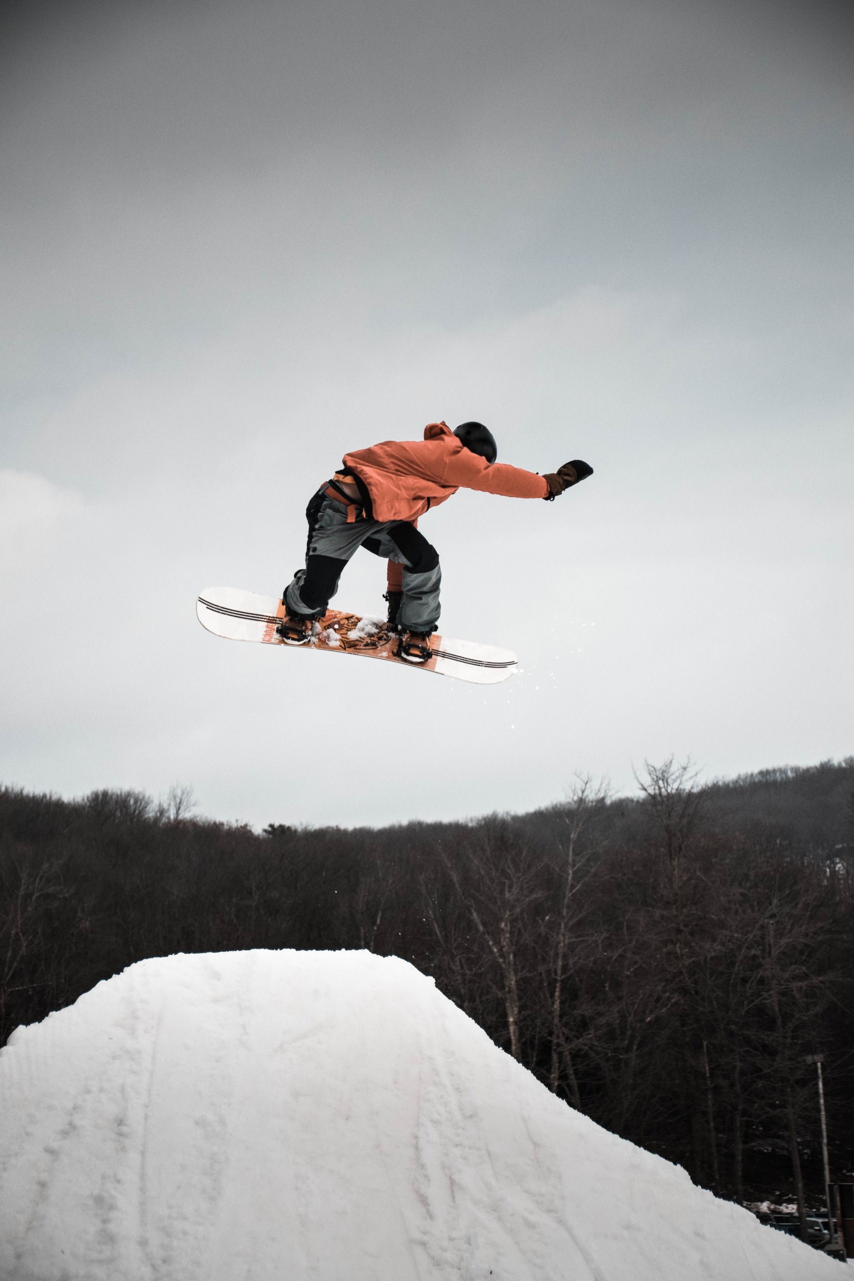 pexels image credit to Tyler Tornberg. Image of snowboarder jumping in air above snow