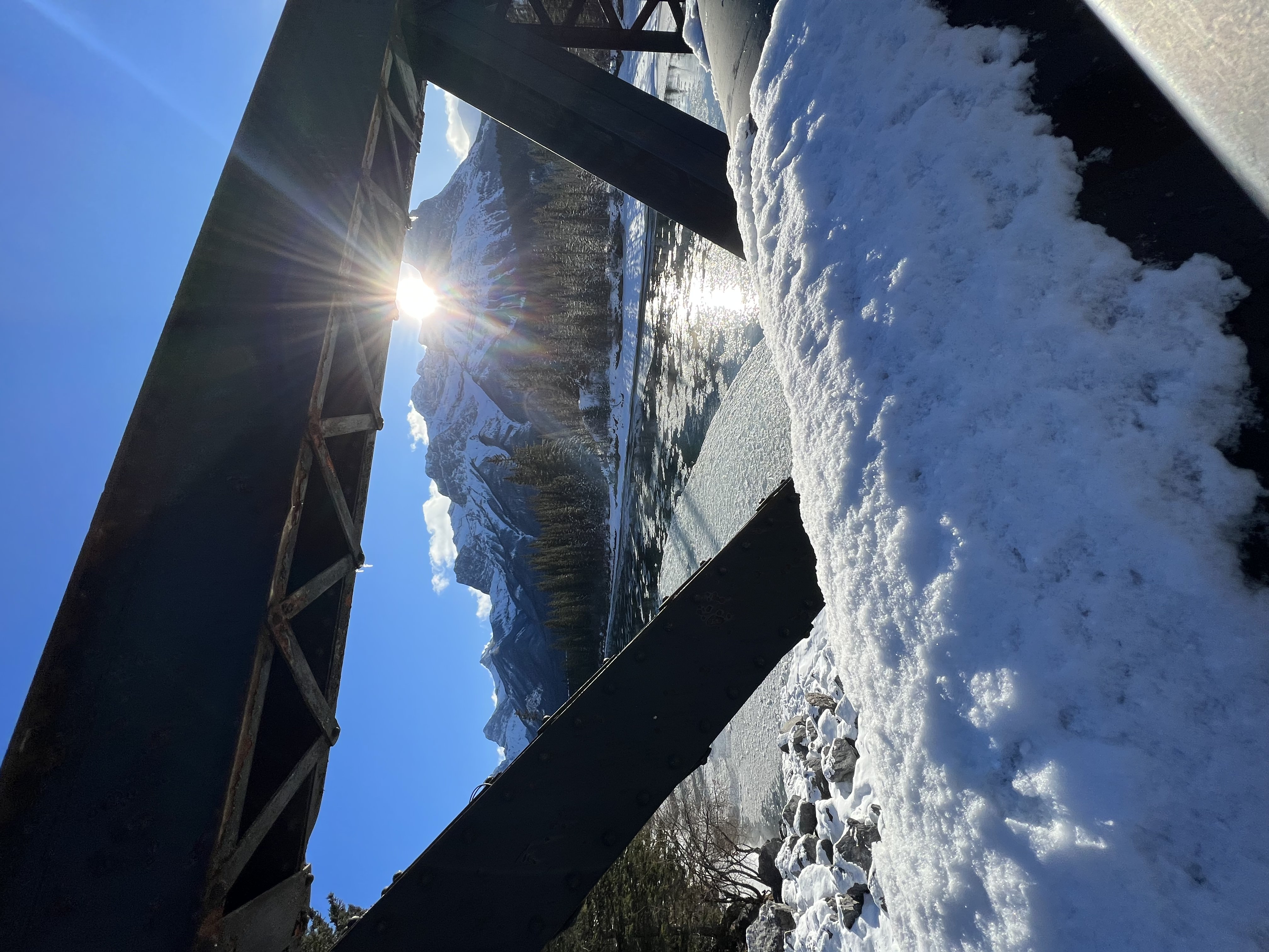 image of Canmore Engine Bridge in Canmore Alberta Canada. Filming Location for The Last of Us. Image taken on the bridge and looking through a gap in the left hand side to show mountain and river.