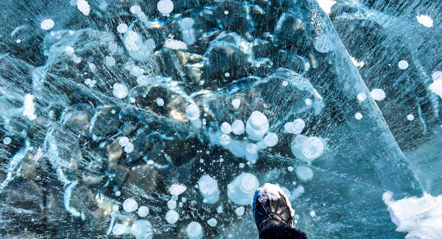 Shireen's right foot on top of Frozen Ice Bubbles in Abraham Lake, Canada