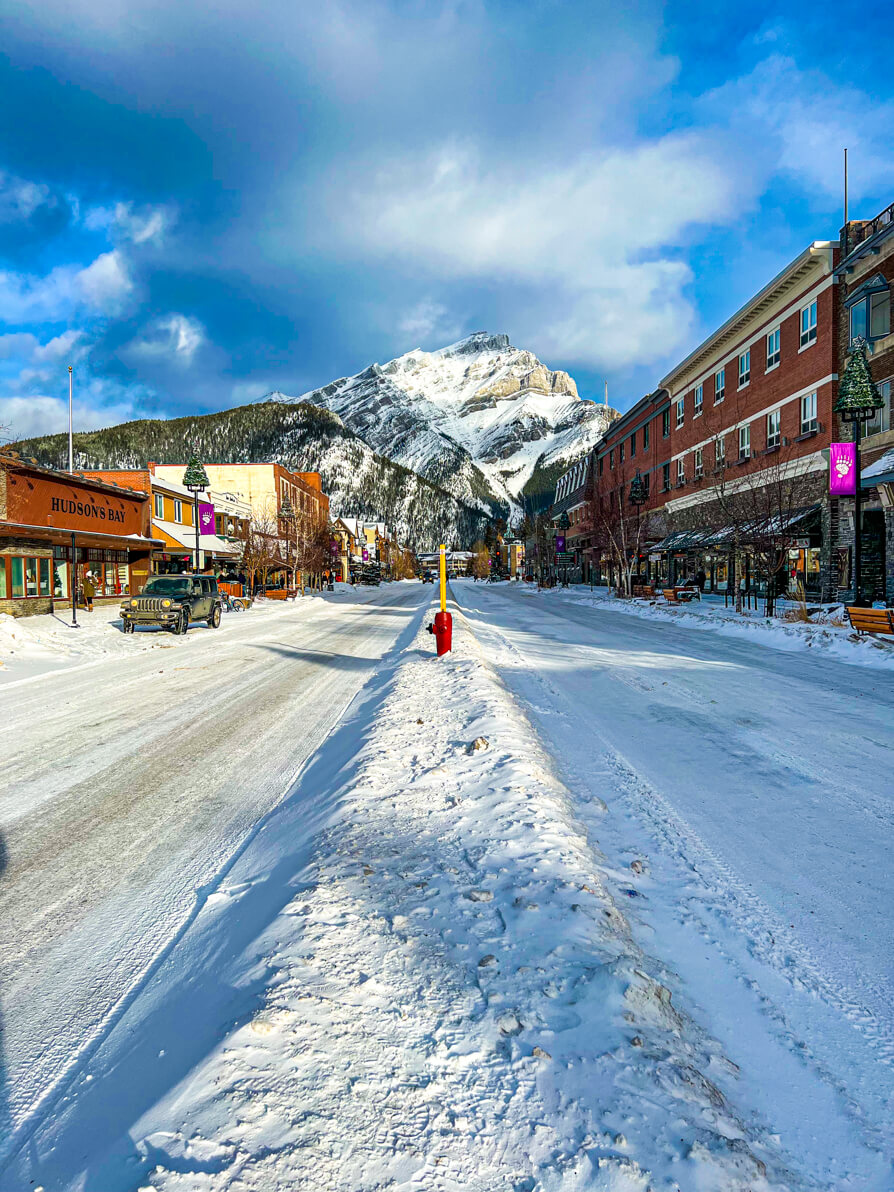 image of Banff Avenue Christmas with snow filled streets and Cascade Mountain in background